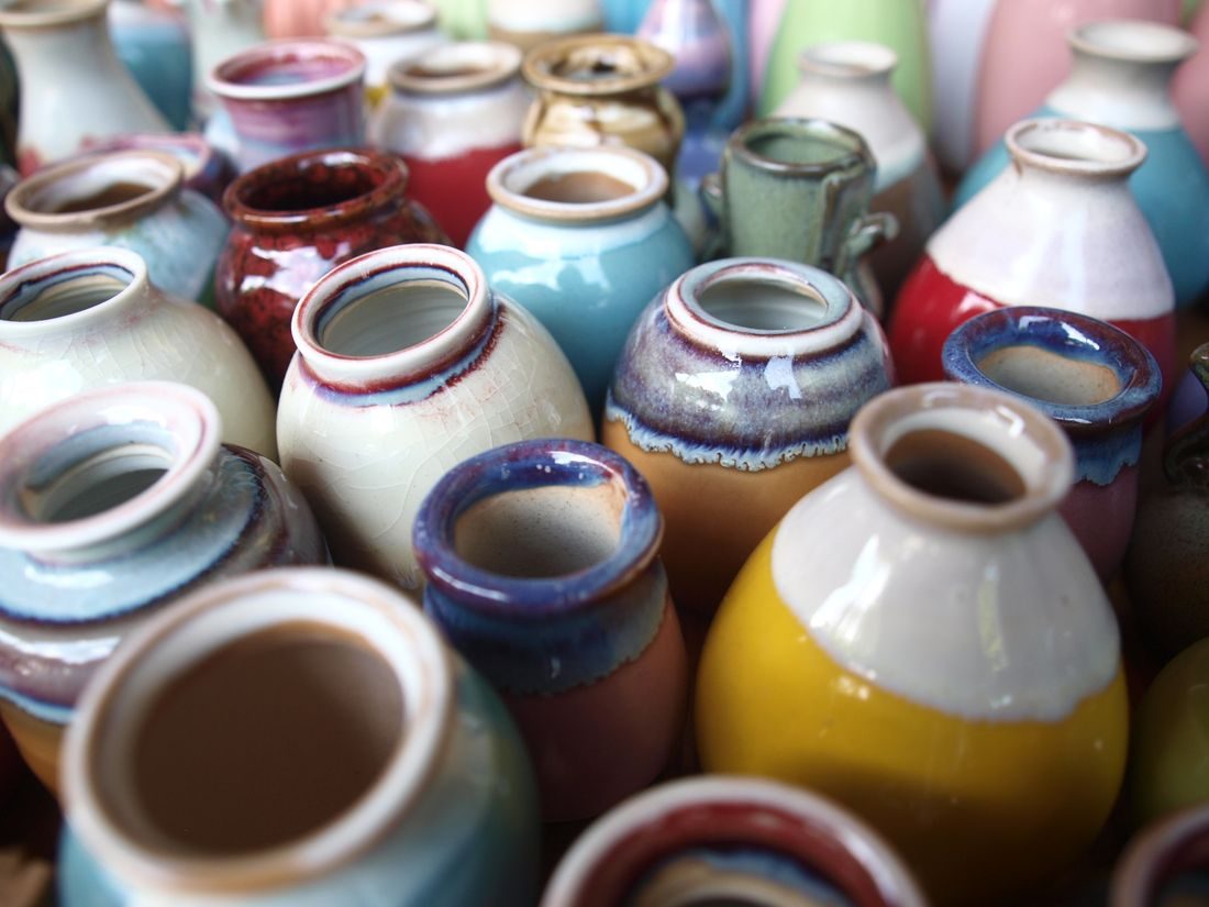 A group of small handmade ceramic vases in different colours.