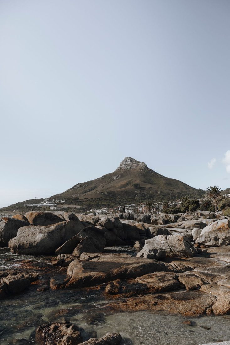 Rocks in the foreground of a coastal mountain landscape.