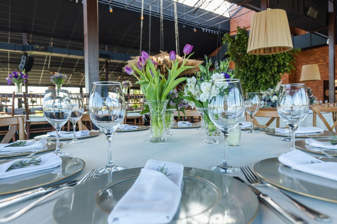 Glassware, flowers and place settings on an event table.