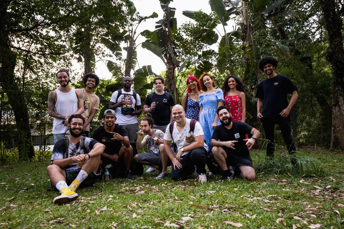 A group of people posing together outdoors under trees.