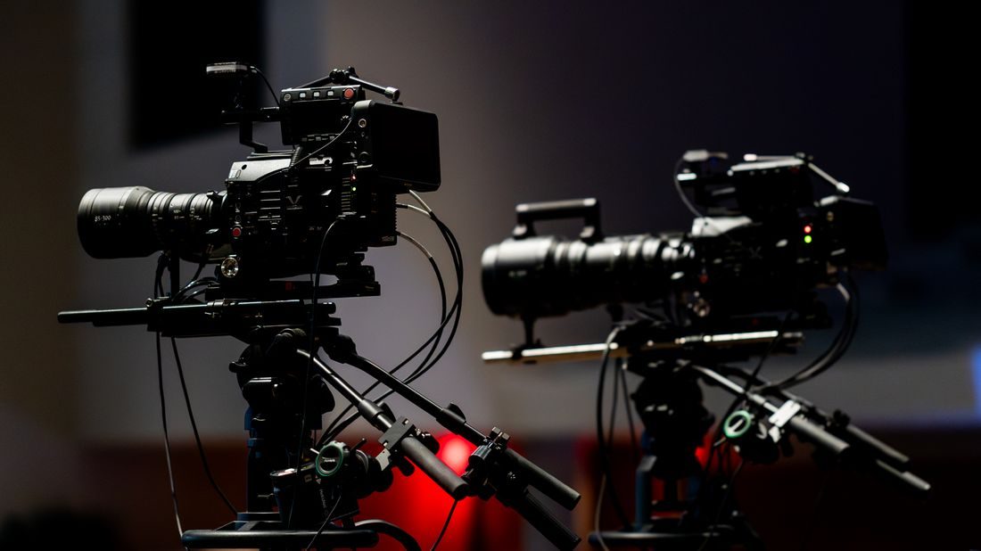 Two video cameras positioned beside each other in a studio.