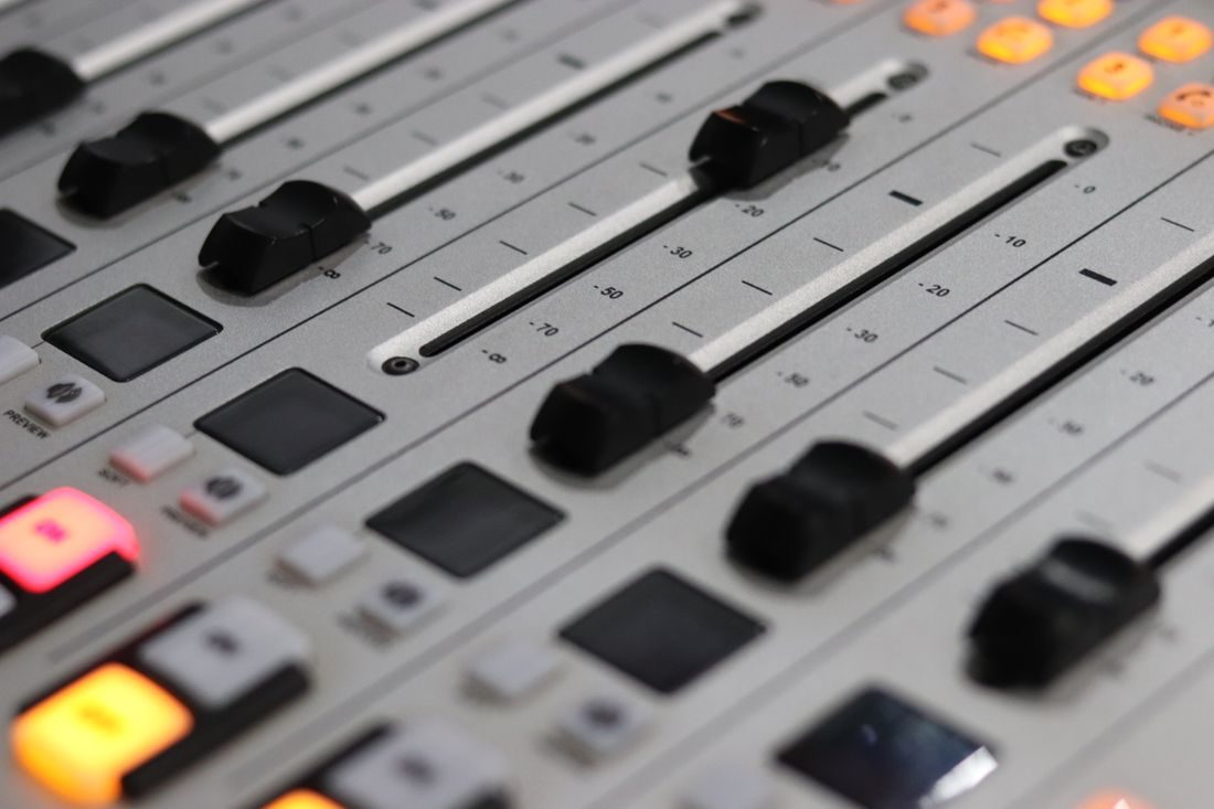 A close view of faders on an audio mixing desk.