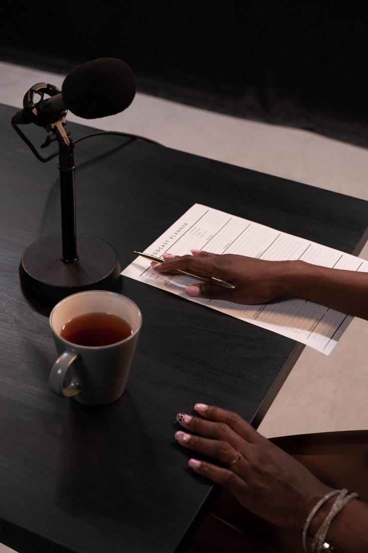 A microphone beside a notebook and cup of tea.
