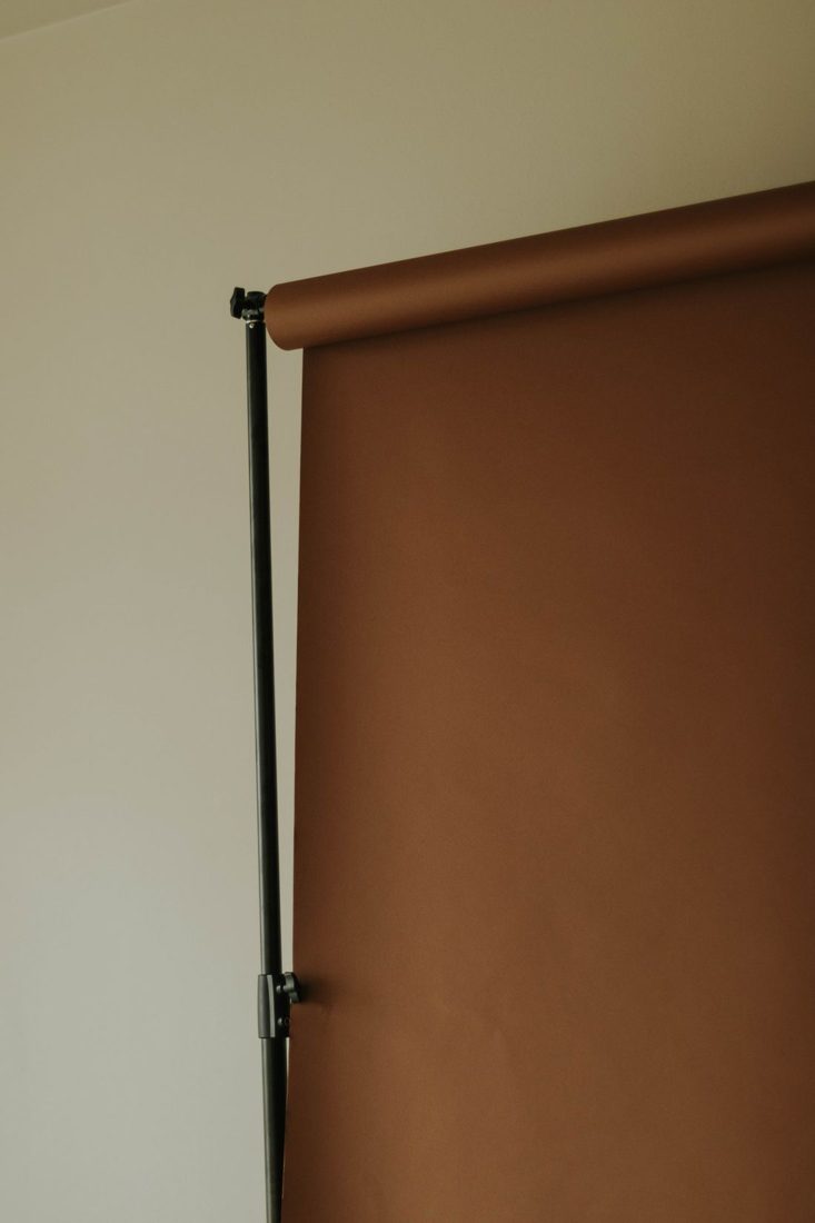 A brown photography backdrop mounted on a stand.